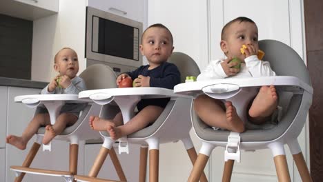 Curious-Triplets-Biting-on-Apples-and-Watching-Something