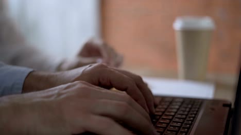 close-up.-men's-hands-actively-and-quickly-type-on-the-keyboard-of-the-laptop.-Female-in-the-background-helps-pointing-at-the-screen.-concept-team-work.-4K