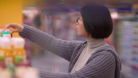 Nahaufnahme-der-schwangeren-asiatischen-Frau-beim-Einkaufen-im-Supermarkt