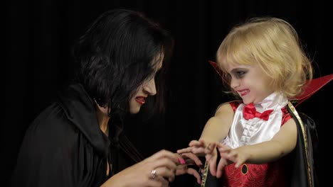 Mujer-e-hijo-Drácula.-Maquillaje-de-vampiros-de-Halloween.-Niño-con-sangre-en-la-cara