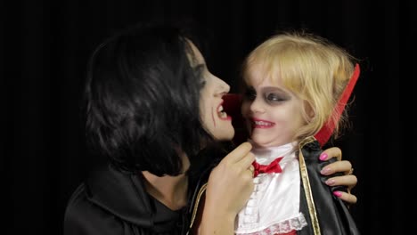 Woman-and-child-dracula.-Halloween-vampire-make-up.-Kid-with-blood-on-her-face