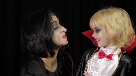 Frau-und-Kind-dracula.-Halloween-Vampir-Make-up.-Kind-mit-Blut-im-Gesicht