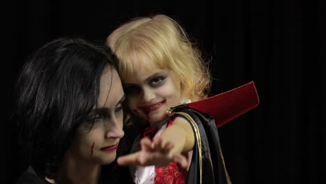 Woman-and-child-dracula.-Halloween-vampire-make-up.-Kid-with-blood-on-her-face