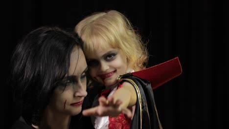 Frau-und-Kind-dracula.-Halloween-Vampir-Make-up.-Kind-mit-Blut-im-Gesicht