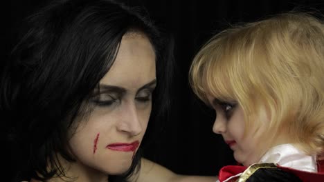 Mujer-e-hijo-Drácula.-Maquillaje-de-vampiros-de-Halloween.-Niño-con-sangre-en-la-cara