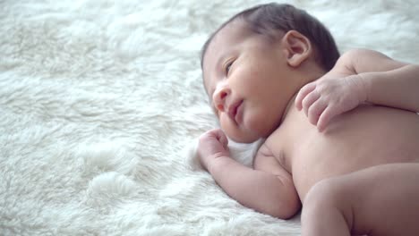 4K-Mittlere-Aufnahme-von-entspannenden-entzückenden-kleinen-asiatischen-Neugeborenen-Junge-Sohn-schlafen-auf-weißem-Bett-im-Schlafzimmer-zu-Hause.-Süße-unschuldige-Neugeborene-Gesundheit-Pflege-und-empfindliche-Haut-Konzept.
