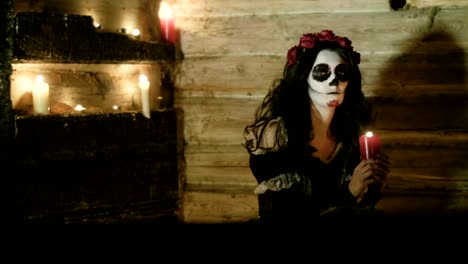 Junge-Frau-mit-beängstigend-Skelett-Halloween-Make-up-hält-eine-beleuchtete-Kerze.-Hd