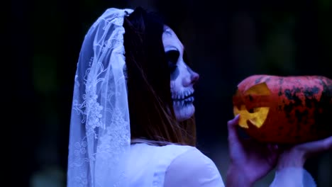 Halloween.-The-woman-holding-in-the-arms-a-pumpkin-with-a-burning-wax-candle.-4K