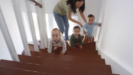 Asiatische-Baby-Triplets-und-Mama-auf-Treppe