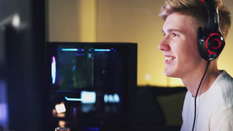 Teenage-Boy-Wearing-Headset-Gaming-At-Home-Using-Dual-Computer-Screens