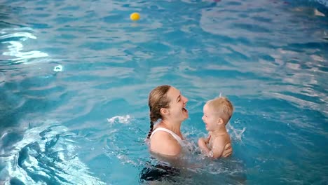 Piscina.-Mamá-le-enseña-a-un-niño-pequeño-a-nadar-en-la-piscina.