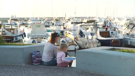 Madre-e-hija-turistas-en-un-puerto-al-atardecer