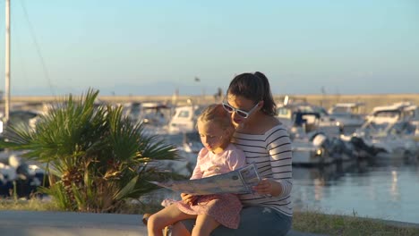 Junge-Frau-mit-Tochter-lesen-touristische-Karte