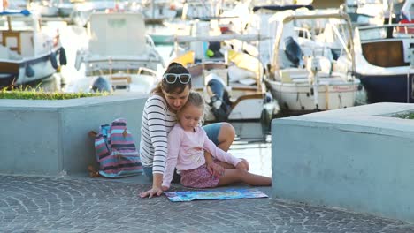 Frau-mit-Tochter-Blick-auf-eine-Karte-in-der-Nähe-von-Marina