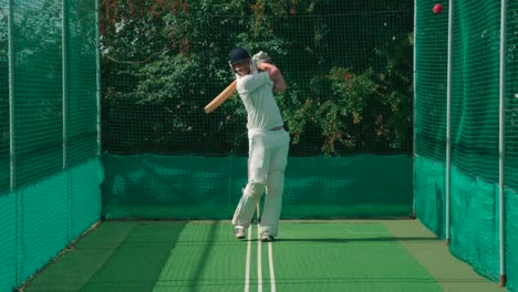 Un-jugador-haciendo-práctica-red-pega-a-la-pelota-de-cricket.