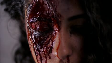 Scary-portrait-of-young-girl-with-Halloween-blood-makeup.-Beautiful-latin-woman-with-curly-hair-looking-into-camera.-Slow-motion