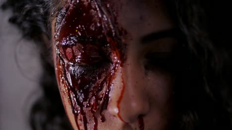 Aterrador-retrato-de-niña-con-maquillaje-de-Halloween-sangre.-Hermosa-mujer-latina-con-cabello-rizado-en-cámara.-Cámara-lenta