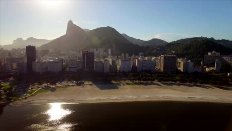 Rio-de-Janeiro-Aerial:-Slow-move-towards-Botafogo-beach-with-buildings-and-Christ-the-Redeemer-in-the-background
