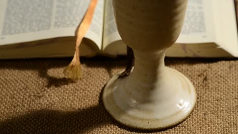 Bibel-mit-Kelch-Wein,-gleiten,-kippen