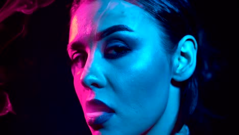 Gorgeous-brunette-woman-smoking-electronic-cigarette-in-neon-color-light