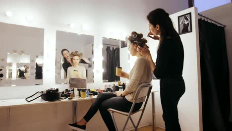 Young-woman-presenter-drinking-coffee-before-morning-TV-show-in-dressing-room