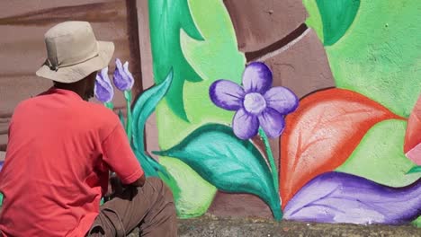 Wandmaler-malt-ein-Garten-Bild-in-Farbe-auf-die-Wand-der-Schule.-Zeitraffer