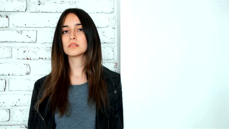 Modelo-morena-en-chaqueta-de-cuero-posando-en-el-estudio-blanco