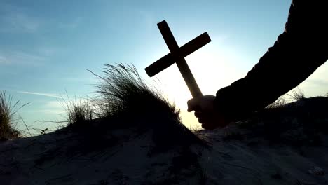 Silhouette-des-Menschen-"Hand-Kreuz-über-den-Sonnenaufgang---Konzept-zur-Religion-erhoben