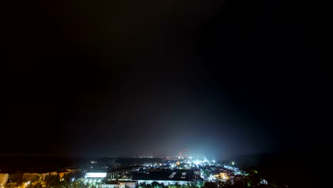 Time-lapse-of-the-thunderstorm-with-lightning-above-industrial-district-at-night.