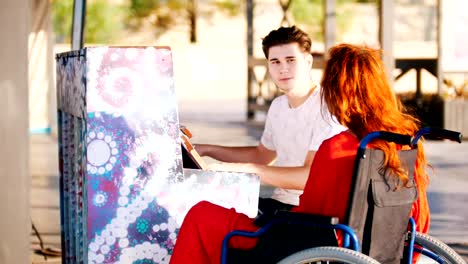 Joven-toca-el-Piano-para-una-niña-de-rojo-en-una-silla-de-ruedas