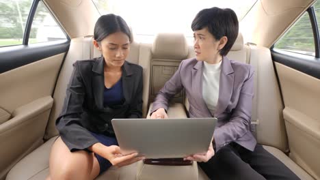 Businesswoman-getting-rebuke-from-his-female-boss-in-the-backseat-of-a-car