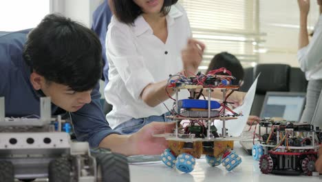 Team-of-electronics-engineer-working-together,-collaborating-on-a-project-to-build-robot.-People-with-technology-or-innovation-concept.