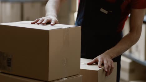 Warehouse-Worker-Collects-Order-by-Taking-Cardboard-Boxes-and-Parcels-of-the-Shelf-and-Putting-them-On-a-Trolley.