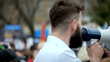 Menschen-in-Stadt-Rallye.-Der-Kerl-schreit-in-den-Lautsprecher.-Die-Masse-auf-der-Straße.