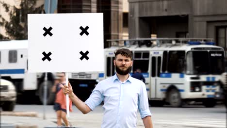 Young-adult-protester-on-the-background-of-a-police-car-at-a-rally-with-a-banner