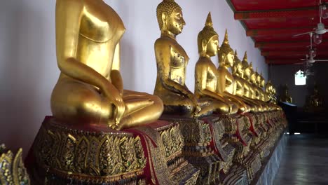 Goldenen-Buddha-Statuen-in-der-Zeile-im-Wat-Pho,-Bangkok-City,-Thailand