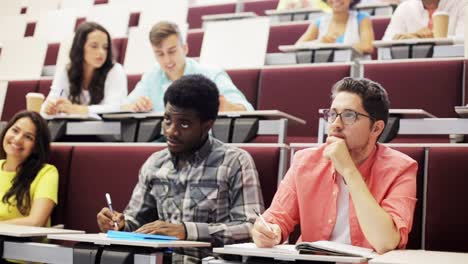 Grupo-de-estudiantes-con-los-cuadernos-en-el-aula