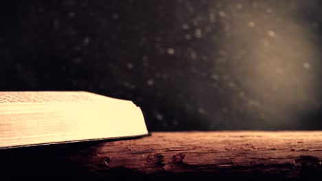 Bible-and-candle-on-a-old-oak-wooden-table.--Beautiful-dark-background.-Religion-concept.