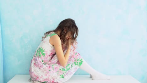 Teenage-girl-crying-at-home-by-covering-her-face-with-hands