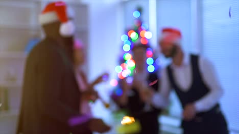 The-four-people-drinking-champagne-near-a-christmas-tree-in-office.-slow-motion