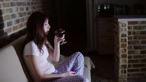 Young-woman-crying-in-front-of-TV-and-drinking-wine