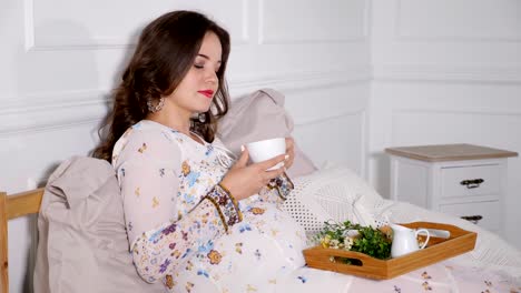 Mujer-embarazada-beber-té-en-la-cama