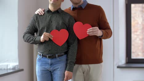 Pareja-gay-masculino-con-forma-de-corazón-rojo-en-el-hogar