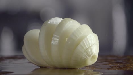 Falling-of-sliced-white-onion-into-the-wet-table.-Slow-motion-240-fps