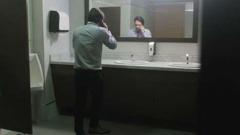 Furious-Business-Man-Screaming-On-Cell-Phone-In-Office-Restroom