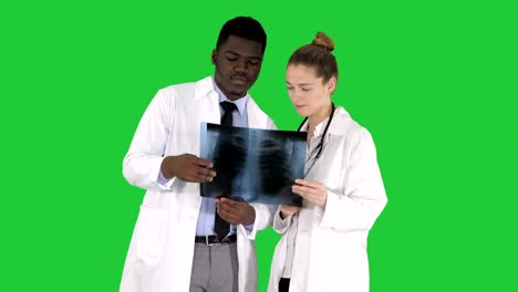 Young-female-doctor-and-afro-american-doctor-looking-at-the-x-ray-picture-of-lungs-on-a-Green-Screen,-Chroma-Key