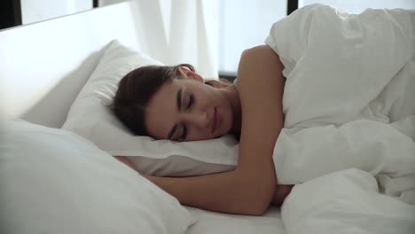 Sleep.-Woman-Sleeping-In-Bed-With-White-Bedding-At-Light-Bedroom