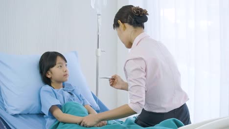 Mother-looking-at-thermometer-after-temperature-measure-her-little-daughter-in-hospital.