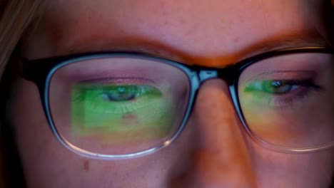 Ziemlich-schöne-Augen-in-der-Nähe-Caucasian-Hacker-Mädchen-schaut-auf-Bildschirm-mit-Informationen-und-es-spiegelt-sich-wie-Bilder-in-ihrer-Brille