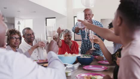 Großvater-steht-am-Esstisch-und-schlägt-einen-Toast-während-einer-Familienfeier,-hautnah